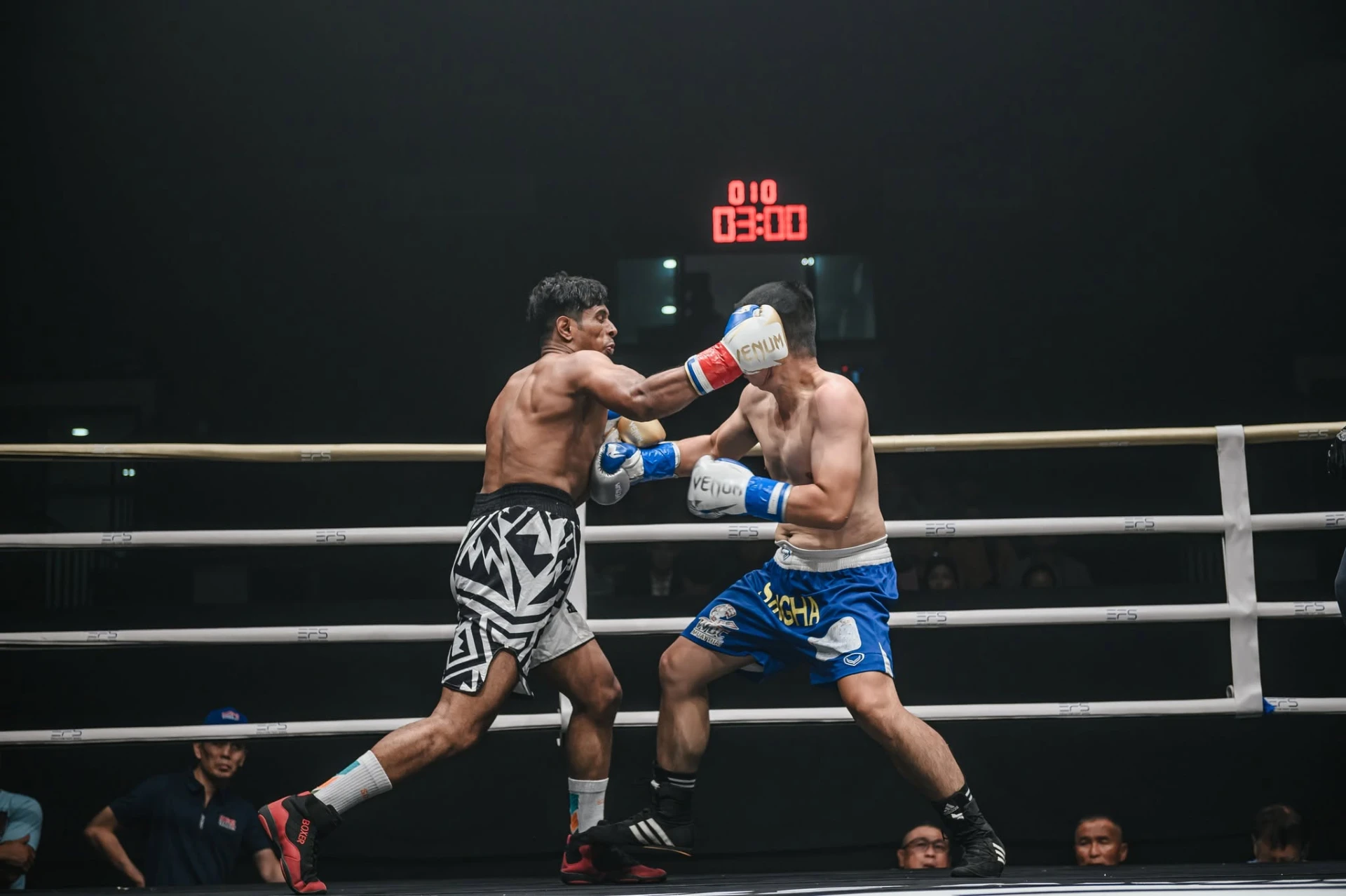 Al-Amin throwing a punch under a spotlight during a professional bout